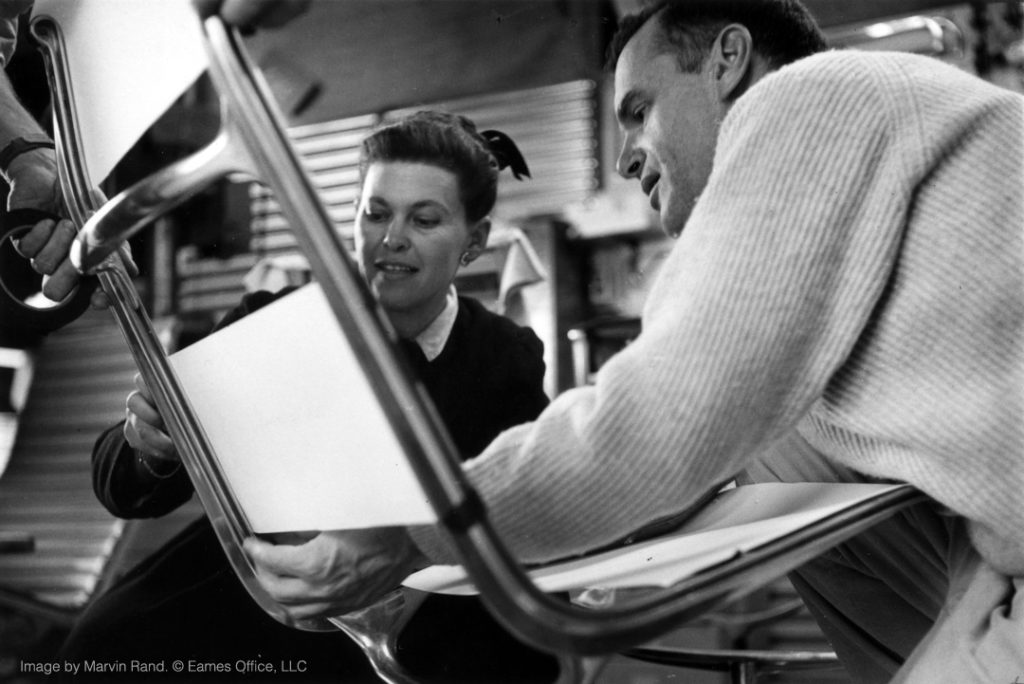 Ray and Charles Eames examining the sling locations to be covered by fabric lapping in a prototype of the Aluminum Group Lounge Chair, 1957, as seen in Jason Cohn and Bill Jersey’s documentary EAMES: The Architect and the Painter. © 2011 Eames Office, LLC.