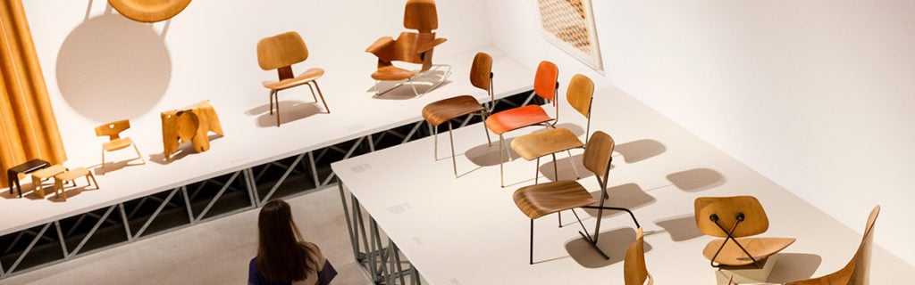 Arial view of Eames chairs displayed on a platform in a museum